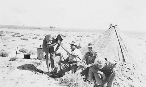 Afrika_korps_soldiers_in_desert_by_camo_tent.jpg
