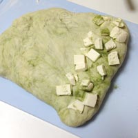 緑のパン生地にクリームチーズを折り込む