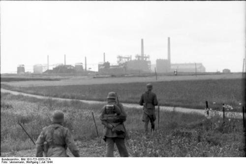 Bundesarchiv_Bild_101I-721-0353-27A,_Collombelles,_Soldaten_auf_Feld_vor_Fabrik.jpg